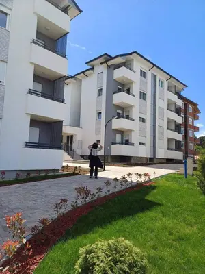 a woman standing in front of a large building at Apartman Pogled Lux - Green Hill Sokobanja in Soko Banja