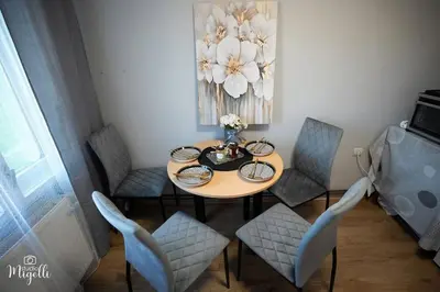 a dining room table with chairs and a vase of flowers at Vila Belgijska pruga in Zaječar