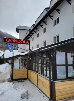a building with a sign on it in the snow at Omorika Brzeće in Brzeće