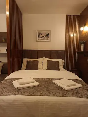 a bedroom with a large bed with two towels on it at Omorika Brzeće in Brzeće