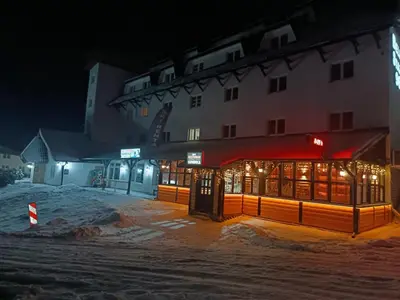 a building with a red awning in the snow at night at Omorika Brzeće in Brzeće