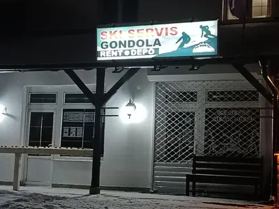 a sign on the side of a building with a bench at Omorika Brzeće in Brzeće