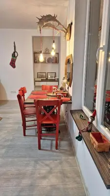 a dining room with a red table and chairs at Play Apartments in Paraćin