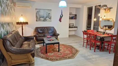 a living room with leather furniture and a table at Play Apartments in Paraćin