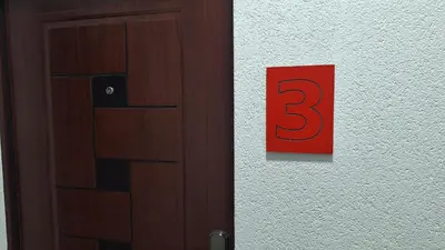 a door with a red sign on a wall at Play Apartments in Paraćin