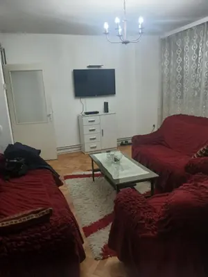 a living room with two beds and a tv at Stan in Niš