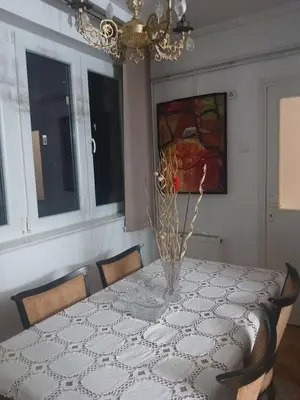 a dining room with a table with a vase on it at Stan in Niš