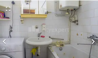 a white bathroom with a sink and a bath tub at Stan in Niš