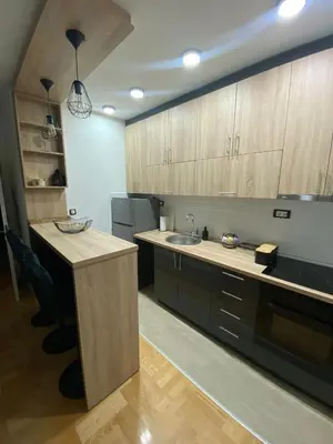 a kitchen with wooden cabinets and a sink and a counter at Mija in Vrnjačka Banja