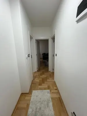 a hallway with white walls and a wooden floor at Mija in Vrnjačka Banja