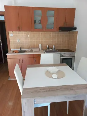 a kitchen with a white table and chairs in it at apartman Nevena in Vrnjačka Banja