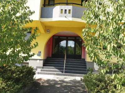 a yellow and white building with stairs and a door at apartman Nevena in Vrnjačka Banja