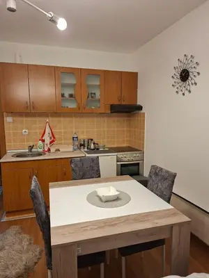 a kitchen with a table with chairs and a counter top at apartman Nevena in Vrnjačka Banja