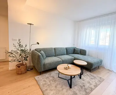 a living room with a couch and a table at Nordic City View Apartment in Niš