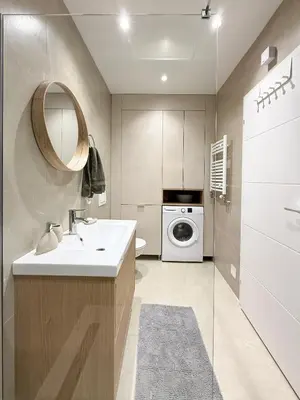 a bathroom with a sink and a washing machine at Nordic City View Apartment in Niš