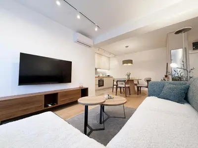 a living room with a couch and a flat screen tv at Nordic City View Apartment in Niš