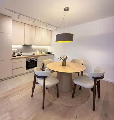 a kitchen with a table and chairs in a kitchen at Nordic City View Apartment in Niš