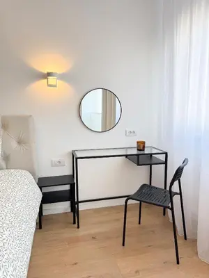 a room with a table and a mirror and a chair at Nordic City View Apartment in Niš