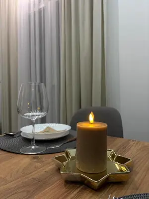 a candle on a table with a plate and a glass at Apartman Brankovic in Jagodina