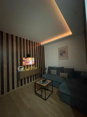 a living room with a blue couch and a table at Apartman Brankovic in Jagodina