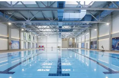 an indoor swimming pool with blue water at Harmony Dream in Jagodina