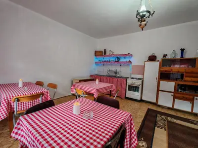a kitchen with two tables and a refrigerator at Apartmani Deda Zarkova Vodenica in Ćuštica
