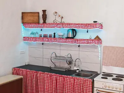 a kitchen with a red and white checkered counter top at Apartmani Deda Zarkova Vodenica in Ćuštica