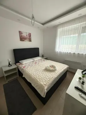 a bedroom with a large bed and a desk at Apartman Petra Sokobanja in Soko Banja