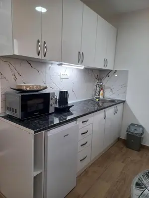 a kitchen with white cabinets and a microwave at Planinski san in Kopaonik
