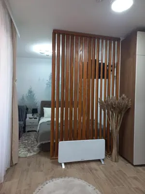 a living room with a bed and a white heater at Planinski san in Kopaonik