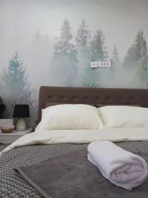 a bedroom with a bed with a blanket and trees at Planinski san in Kopaonik
