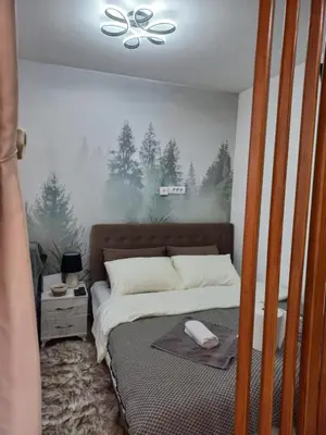 a bedroom with a bed with a painting on the wall at Planinski san in Kopaonik