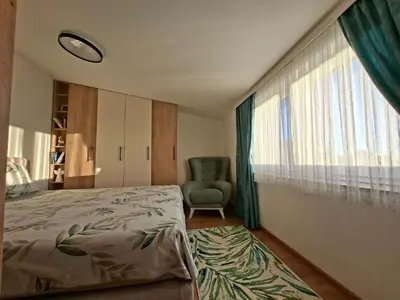 a bedroom with a bed and a chair and a window at Vikvid in Kopaonik