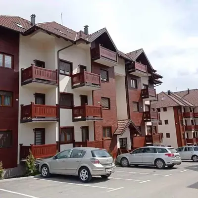 two cars parked in a parking lot in front of a building at Vrnjacka Bajka in Vrnjačka Banja