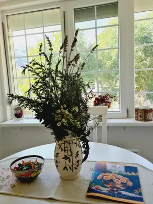 a vase with flowers in it sitting on a table at Vila Nina - gde duša diše in Niška Banja