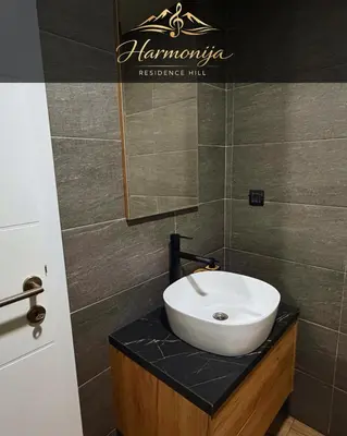 a bathroom with a white sink on a counter at Harmonija Residence Hill 01 in Kopaonik
