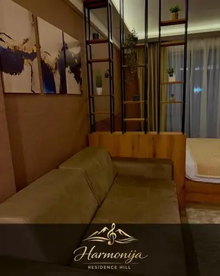 a living room with a couch and a bed at Harmonija Residence Hill 01 in Kopaonik