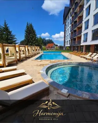 a swimming pool with lounge chairs and a hotel at Harmonija Residence Hill 01 in Kopaonik