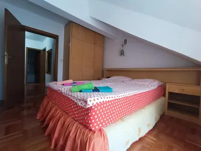 a bedroom with a bed with a red and white polka dot blanket at Apartman Paunov Breg in Vrnjačka Banja