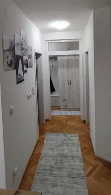 a room with a hallway with white walls and a rug at Apartman Ognjen Vrnjacka Banja in Vrnjačka Banja