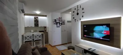 a living room with a couch and a tv on a wall at Apartman Ognjen Vrnjacka Banja in Vrnjačka Banja