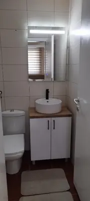 a bathroom with a sink and a toilet and a mirror at Apartman Ognjen Vrnjacka Banja in Vrnjačka Banja