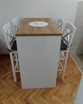 a table with four chairs and a clock on it at Apartman Ognjen Vrnjacka Banja in Vrnjačka Banja