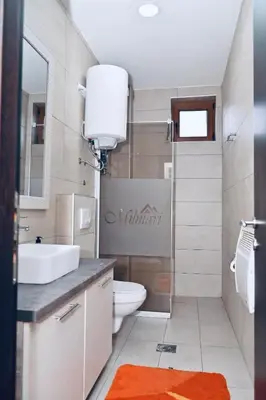 a bathroom with a toilet and a sink and a mirror at K8 Milmari in Kopaonik
