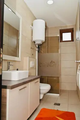 a bathroom with a sink and a toilet and a mirror at K8 Milmari in Kopaonik