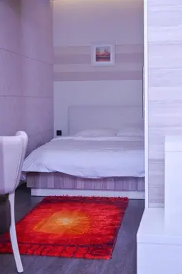 a bedroom with a bed and a red rug at K8 Milmari in Kopaonik
