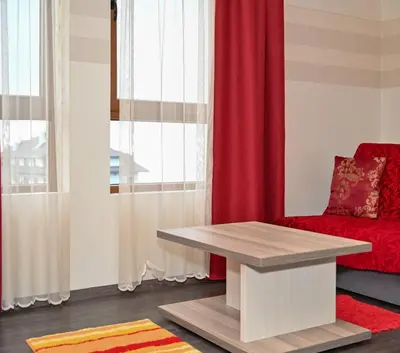 a living room with a red couch and a table at K8 Milmari in Kopaonik