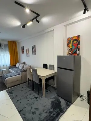 a kitchen and living room with a table and a refrigerator at Nik 1 in Kruševac