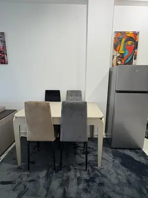 a dining room table with two chairs and a refrigerator at Nik 1 in Kruševac