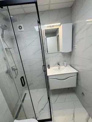 a bathroom with a shower and a sink and a mirror at Nik 1 in Kruševac
